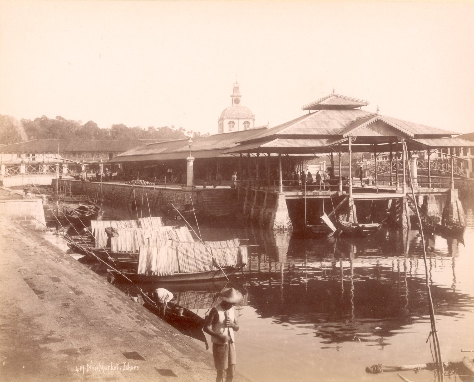 New Market, Johore, photographed around 1900: a covered market on the water with lighters moored along the quay.