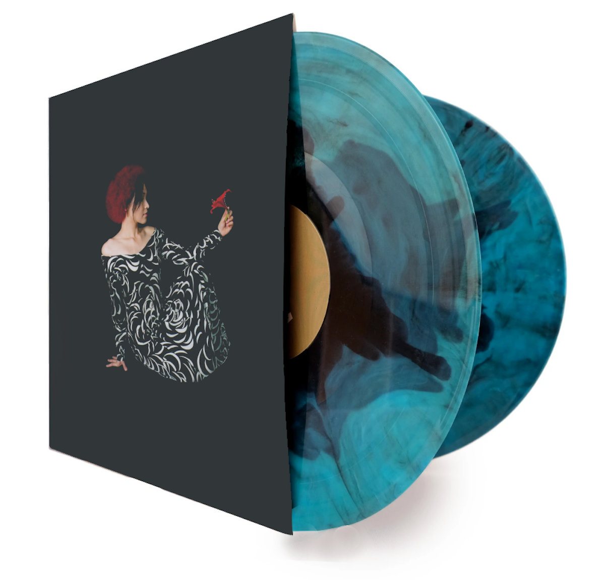 The Fortressa double LP out of its sleeve: two teal and black marbled vinyl records, the album artwork on the sleeve showing a figure in a patterned dress against a dark sky.